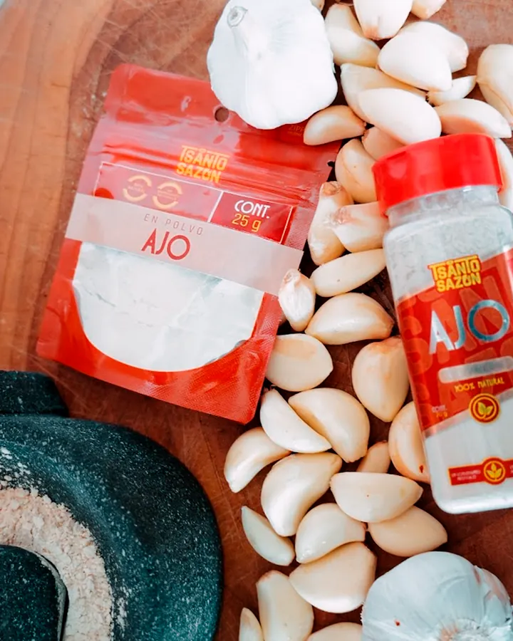 Pouch y frasco de ajo Tsanto Sazón junto a dientes de ajo